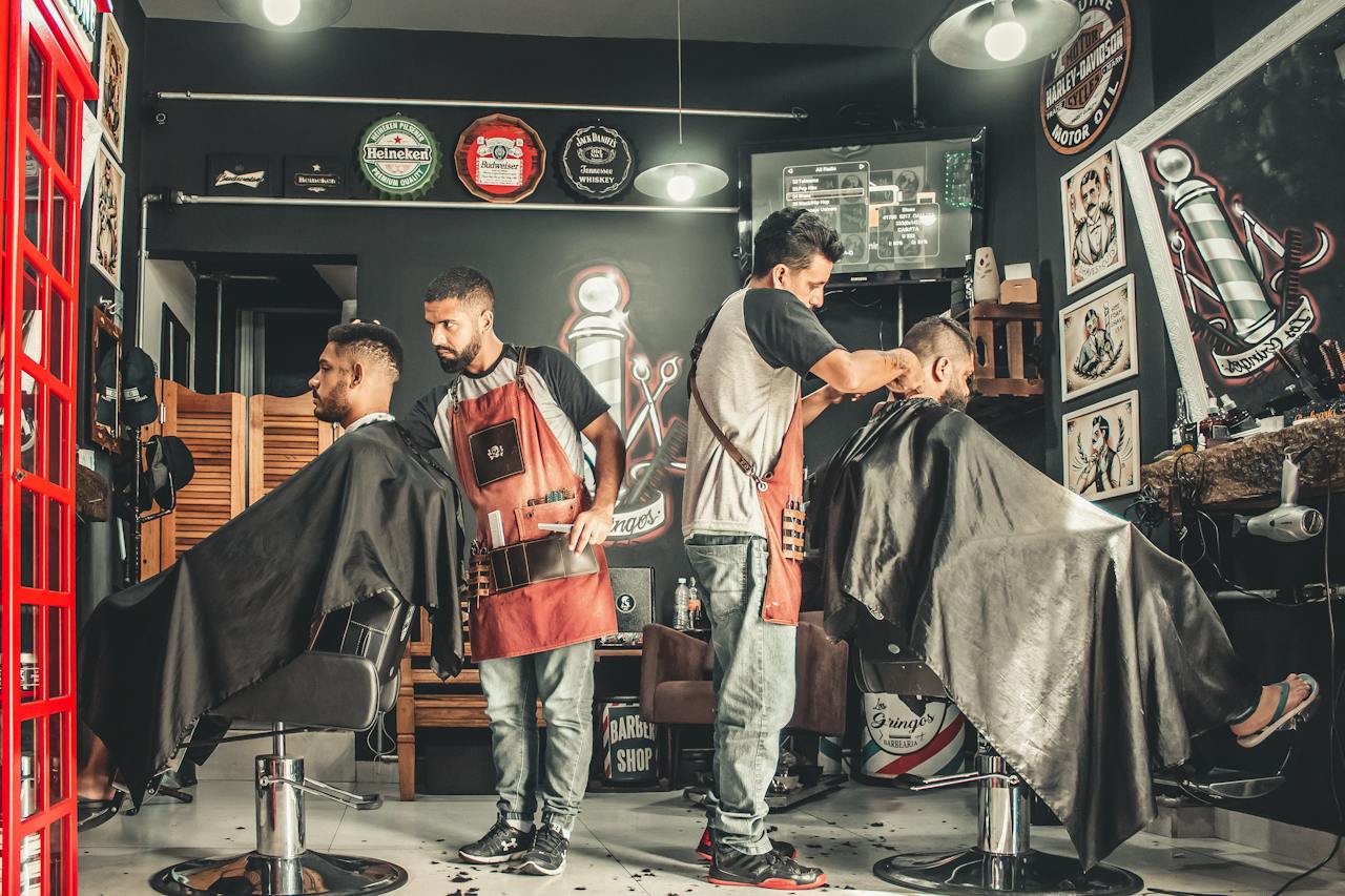 Three men getting haircuts in a barber shop. Professional grooming services in a business setting.